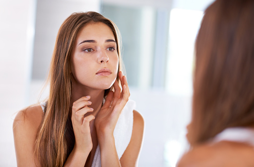 Woman touching her cheek that could have oral cancer.