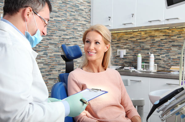 Woman talking to dentist during dental exam at Brush & Floss Dental Center in Stratford, CT